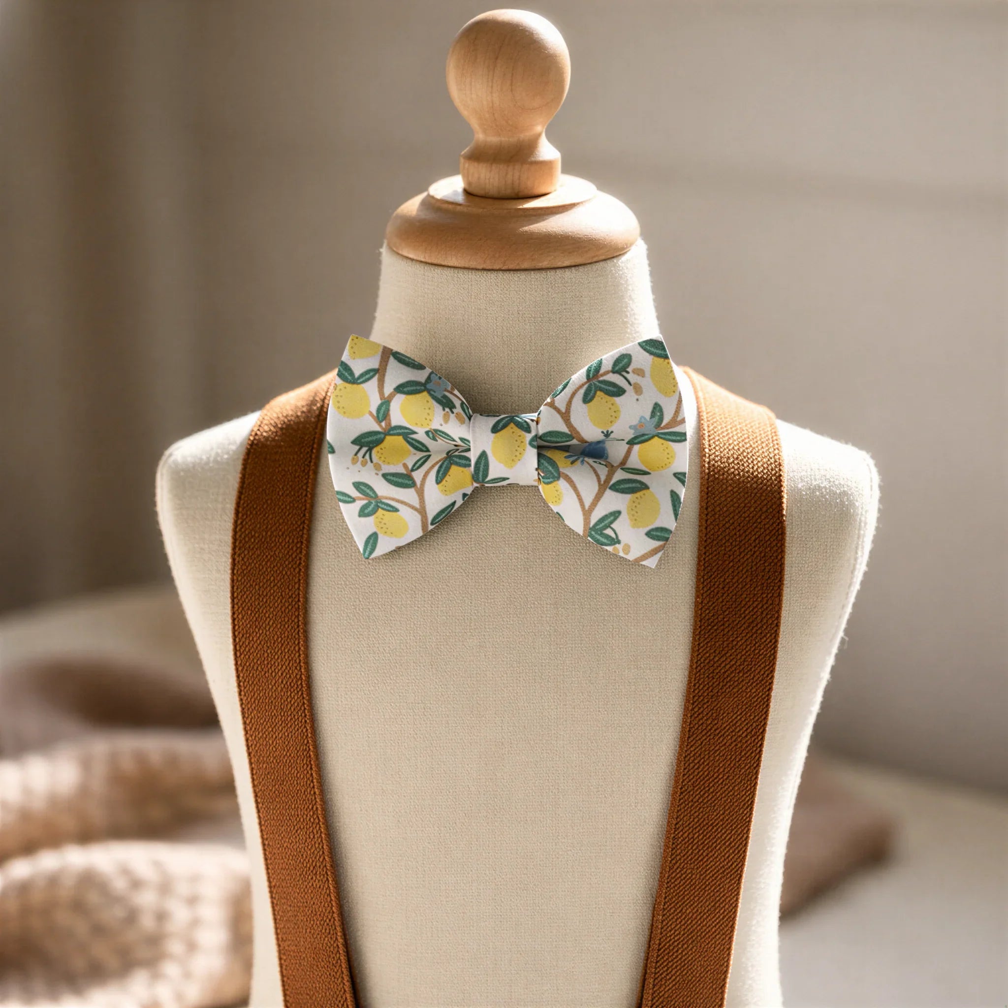 Size chart for pre-tied bow ties from The Bold Bow Tie detailing measurements across three sizes. Small is 3.5 inches wide and recommended for ages 6 months to 5 years. Medium is 4 inches wide and recommended for ages 6 to 12 years. Large is 4.5 inches wide and recommended for ages 13 years and up. Visual icons illustrate the relative sizes with horizontal arrows showing that width is measured from wingtip to wingtip. Bottom text notes that all bow ties are pre-tied and ready to add to your outfit.