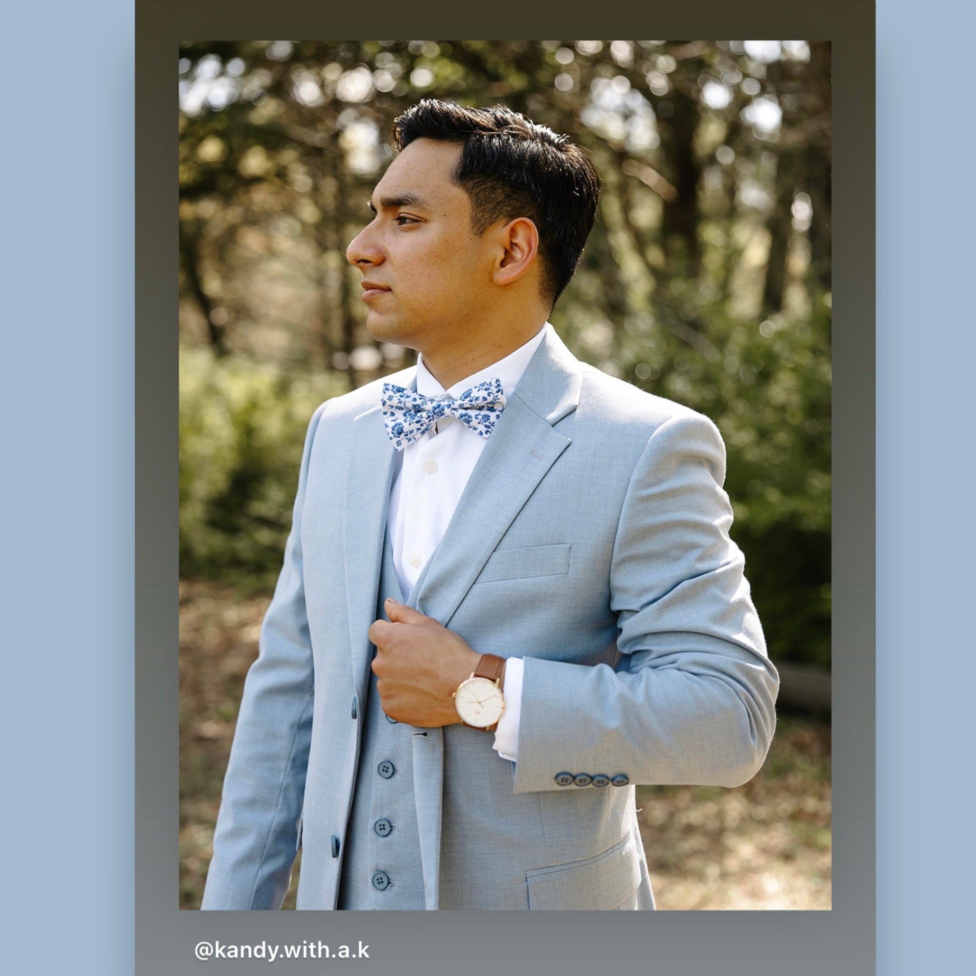 Groomsman in a dusty blue and white floral bow tie at a wedding.