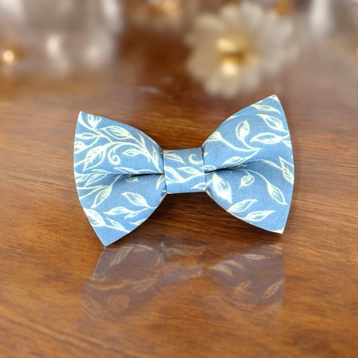 Blue & White Floral Bow Tie for groomsmen, wedding party and ring bearers slanted on a wooden table.