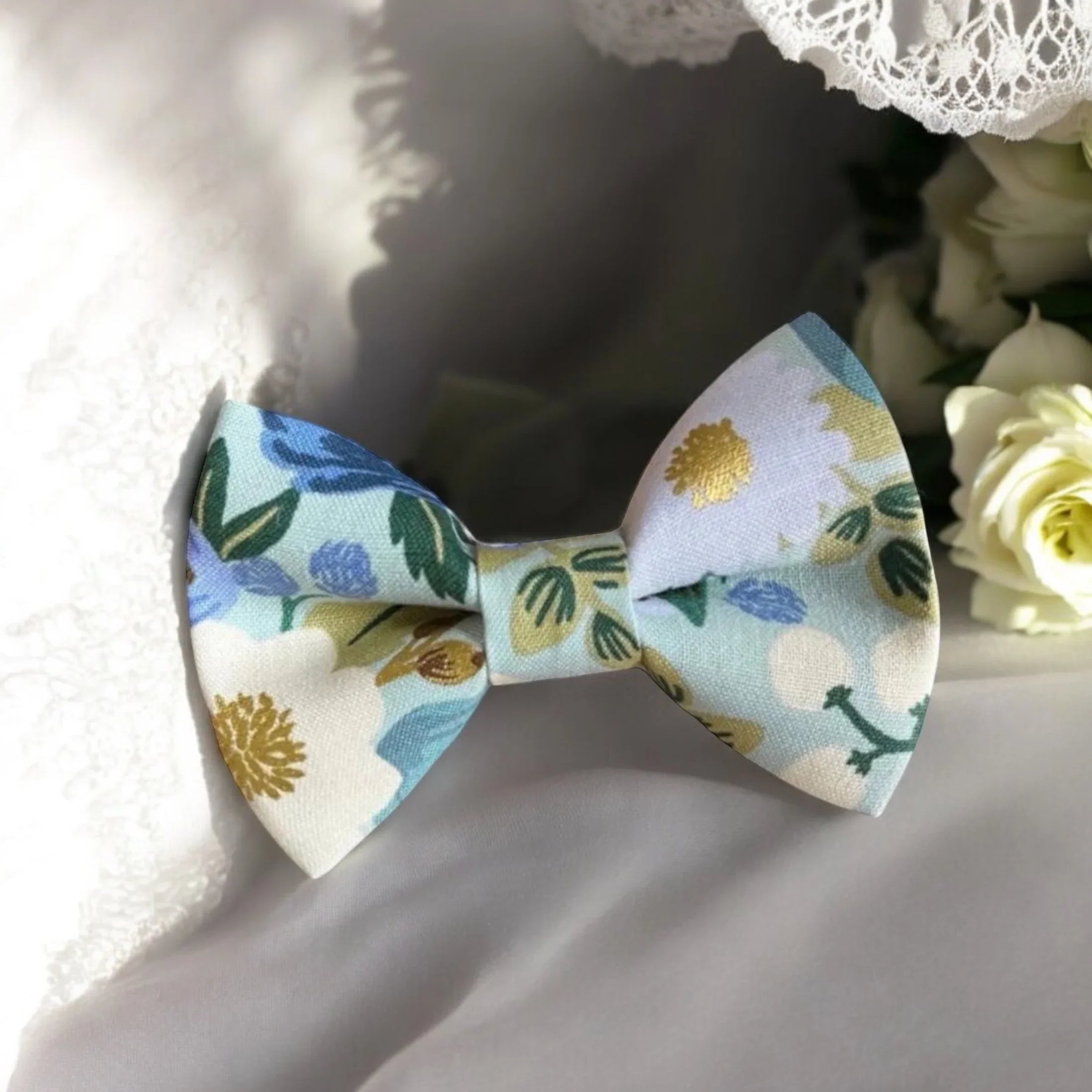 Size chart for pre-tied bow ties from The Bold Bow Tie detailing measurements across three sizes. Small is 3.5 inches wide and recommended for ages 6 months to 5 years. Medium is 4 inches wide and recommended for ages 6 to 12 years. Large is 4.5 inches wide and recommended for ages 13 years and up. Visual icons illustrate the relative sizes with horizontal arrows showing that width is measured from wingtip to wingtip. Bottom text notes that all bow ties are pre-tied and ready to add to your outfit.