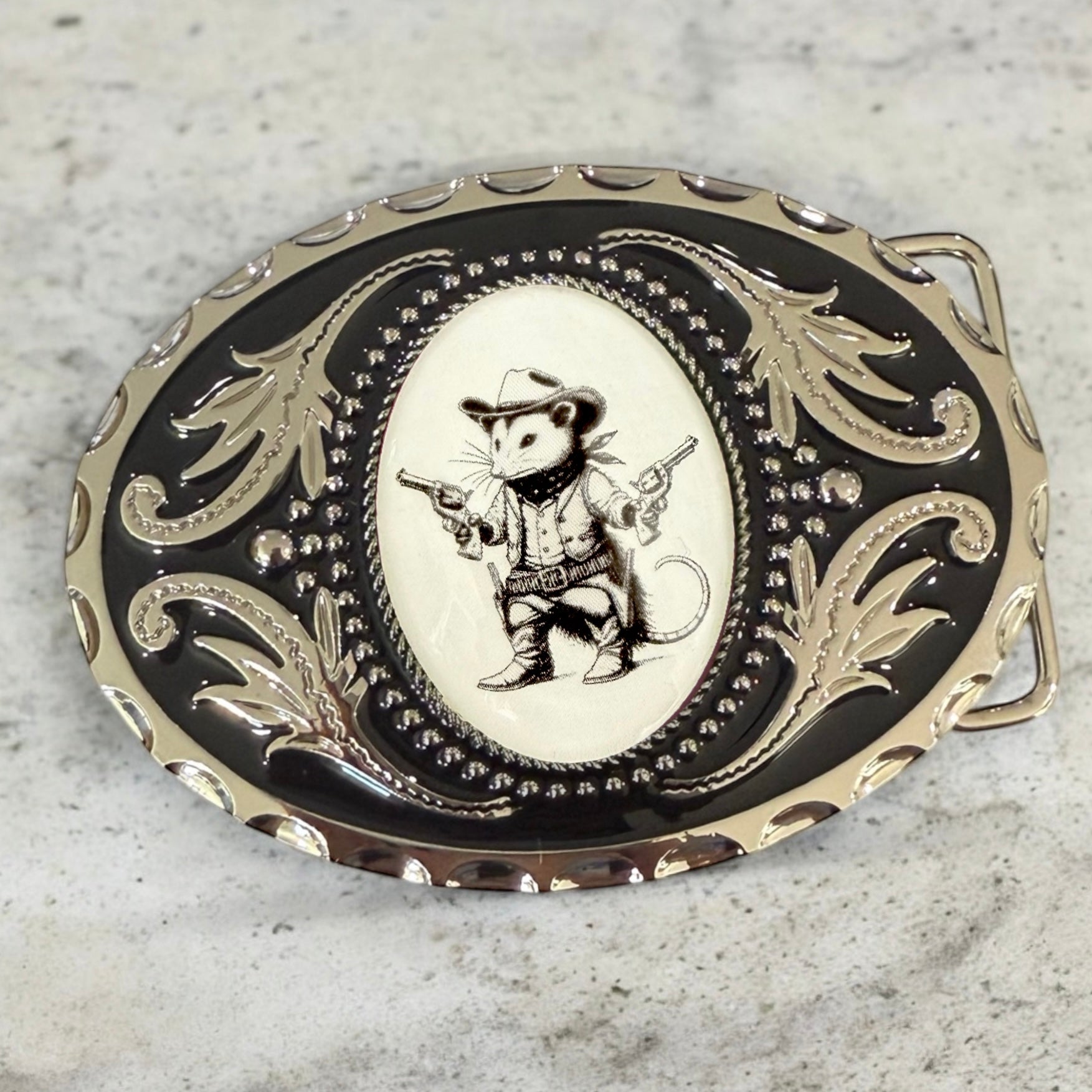 Belt buckle with cowboy design on a textured surface