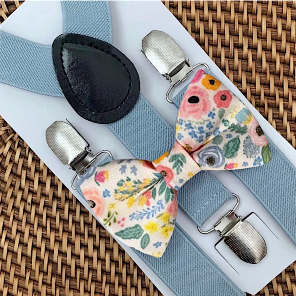 Floral bow tie with silver clips on a woven surface