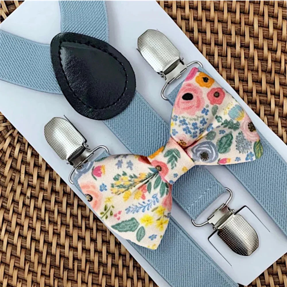 Floral bow tie with silver clips on a woven surface
