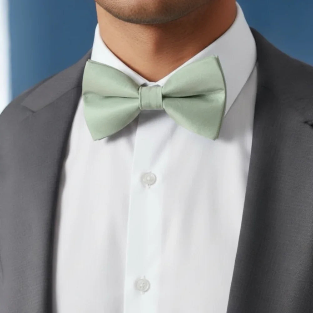 Sage green bow tie worn by a man in a suit at a wedding.