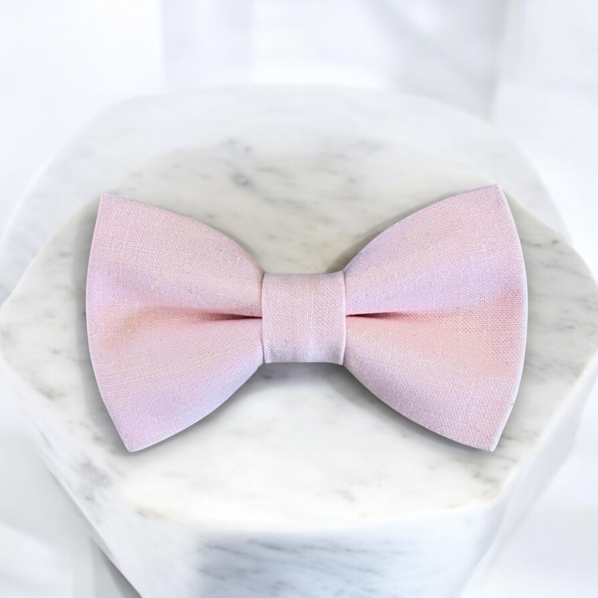Blush bow tie for ring bearer and groomsmen in a wedding.