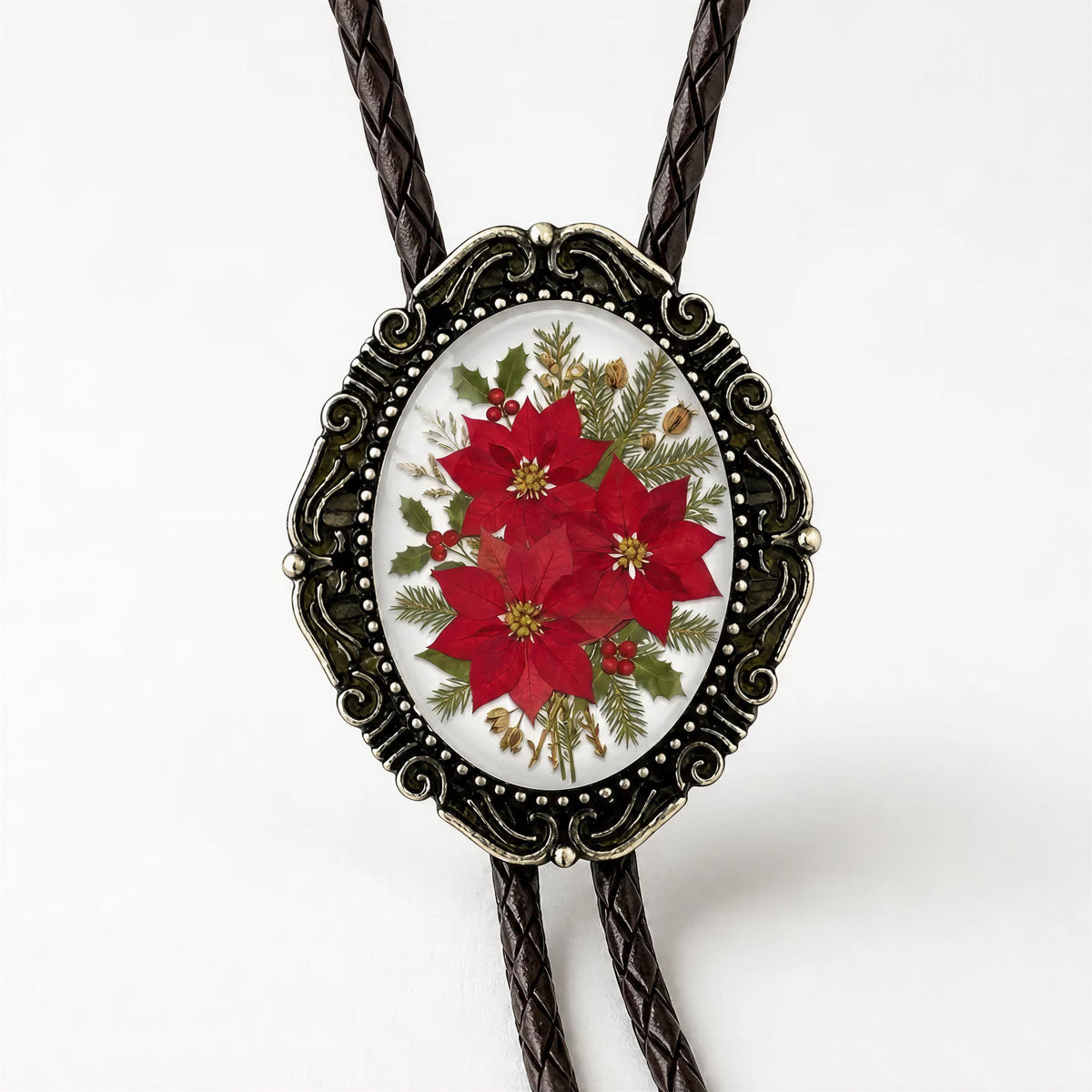 Black braided vegan leather cord bolo tie with decorative antique brass metal tips attached to a large glass dome holiday poinsettia cabochon.