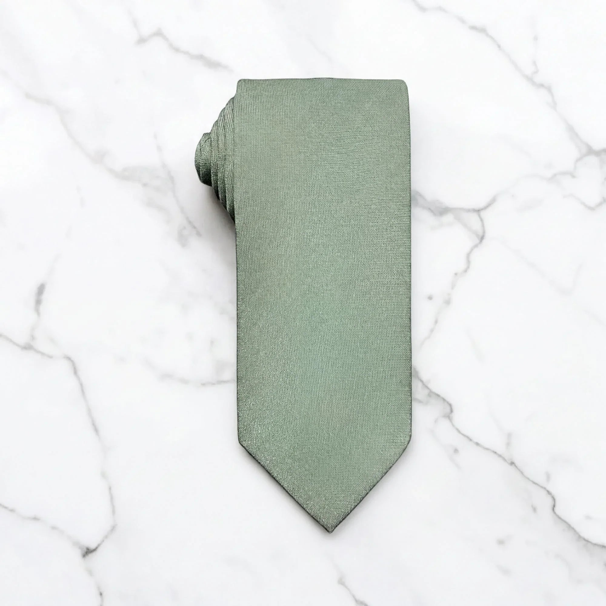 A sage green tie for men’s wedding necktie with a matching fabric neck loop, laid flat on a textured white surface.