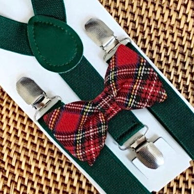 Green suspenders with a red plaid bow tie on a woven surface