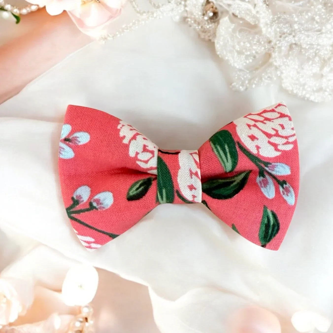Size chart for pre-tied bow ties from The Bold Bow Tie detailing measurements across three sizes. Small is 3.5 inches wide and recommended for ages 6 months to 5 years. Medium is 4 inches wide and recommended for ages 6 to 12 years. Large is 4.5 inches wide and recommended for ages 13 years and up. Visual icons illustrate the relative sizes with horizontal arrows showing that width is measured from wingtip to wingtip. Bottom text notes that all bow ties are pre-tied and ready to add to your outfit.