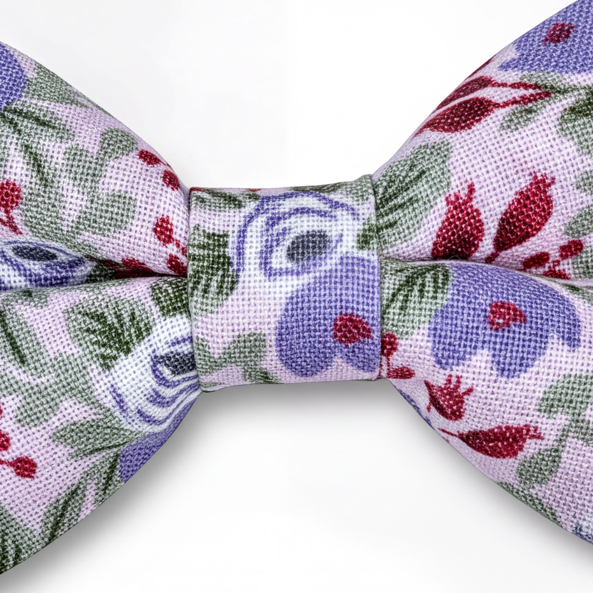 A close-up view of a bow tie with a floral pattern in shades of purple, green, and red.