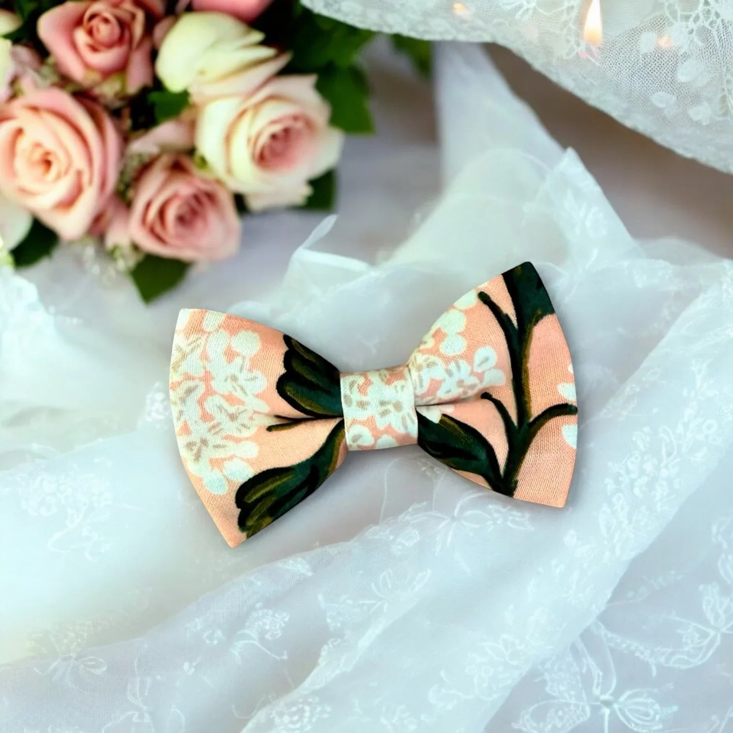 Floral-patterned bow tie on a white fabric background with pink roses.