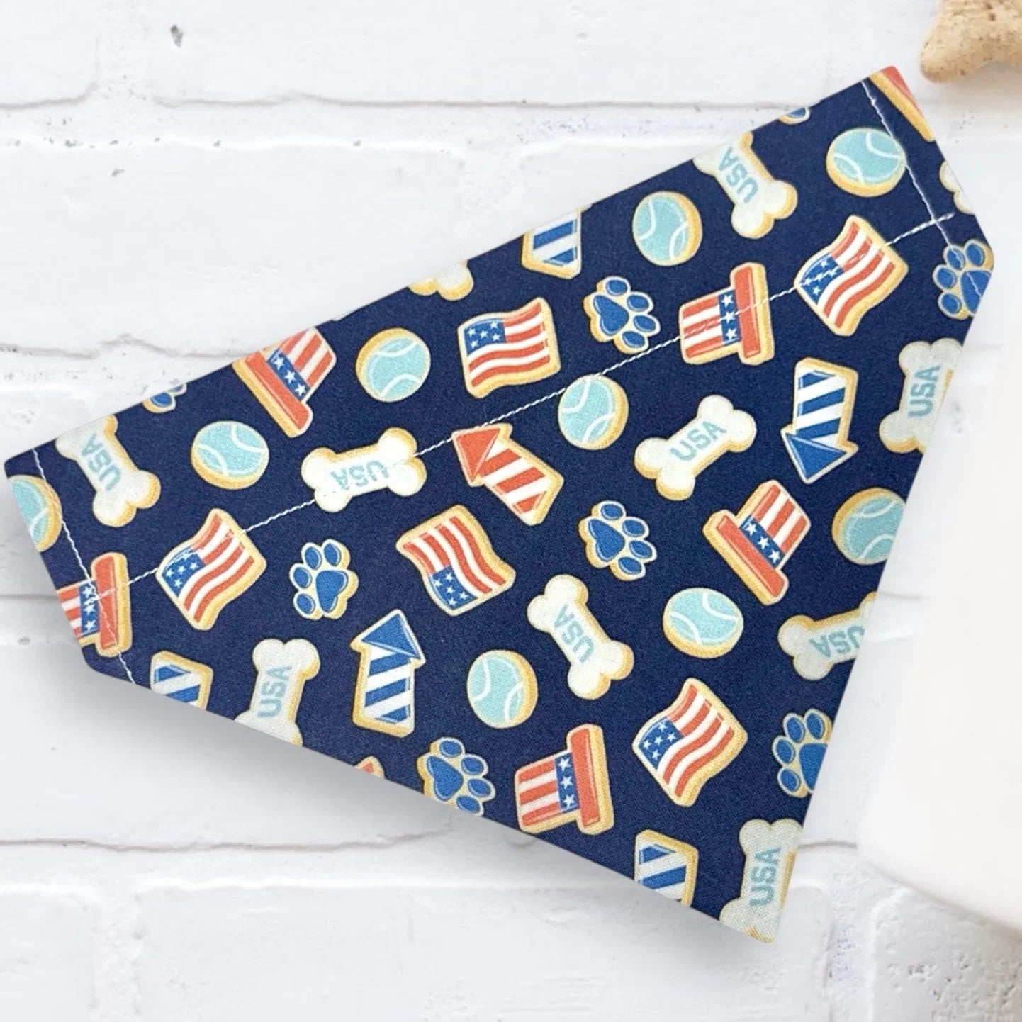Navy blue dog bandana with USA-themed patterns on a white surface