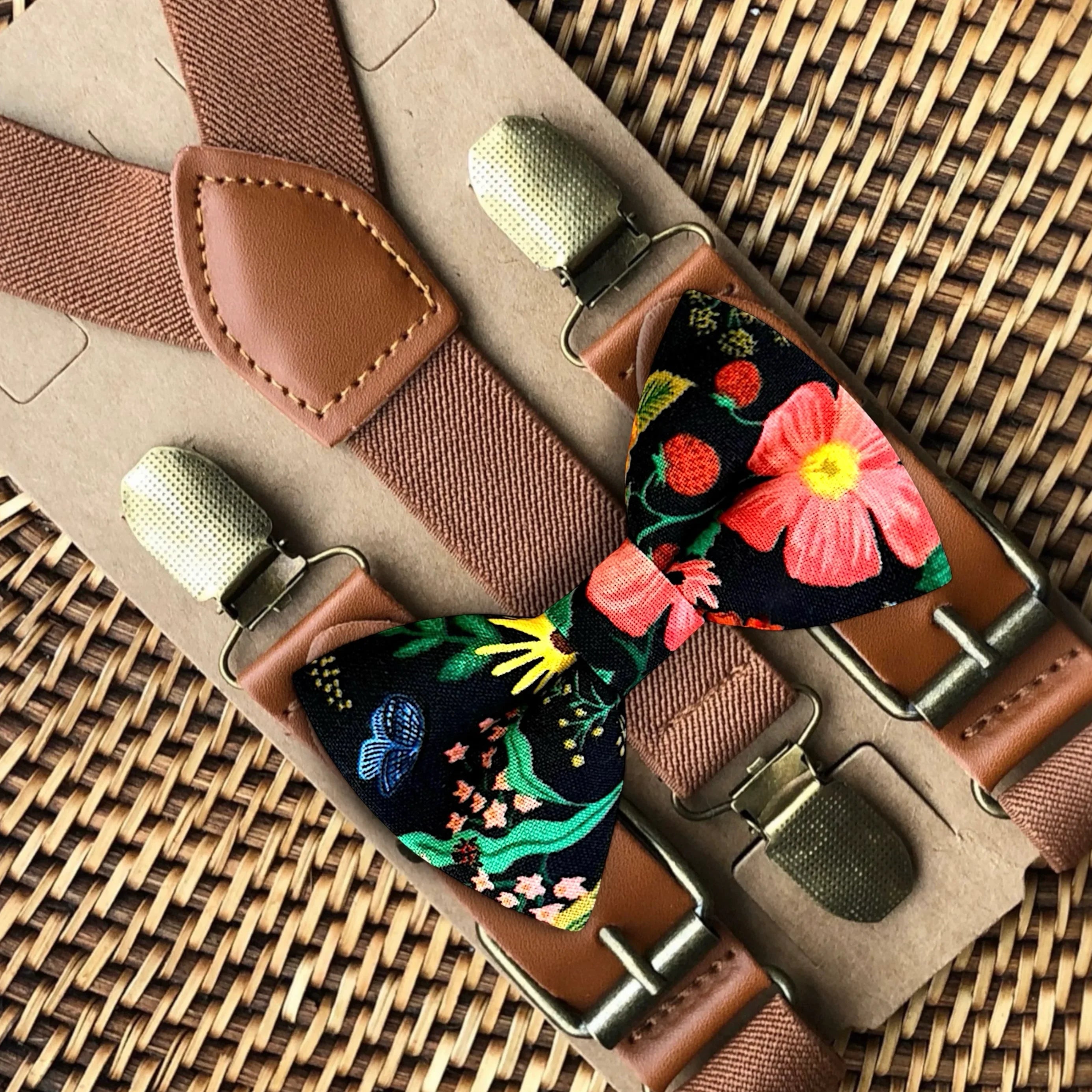 Floral bow tie and suspenders set on a woven surface