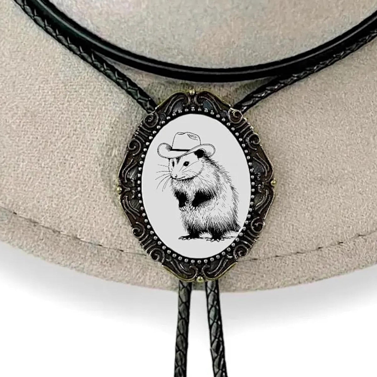 A decorative biker or cowboy hat pin featuring a cartoon image of a hamster wearing a cowboy hat.