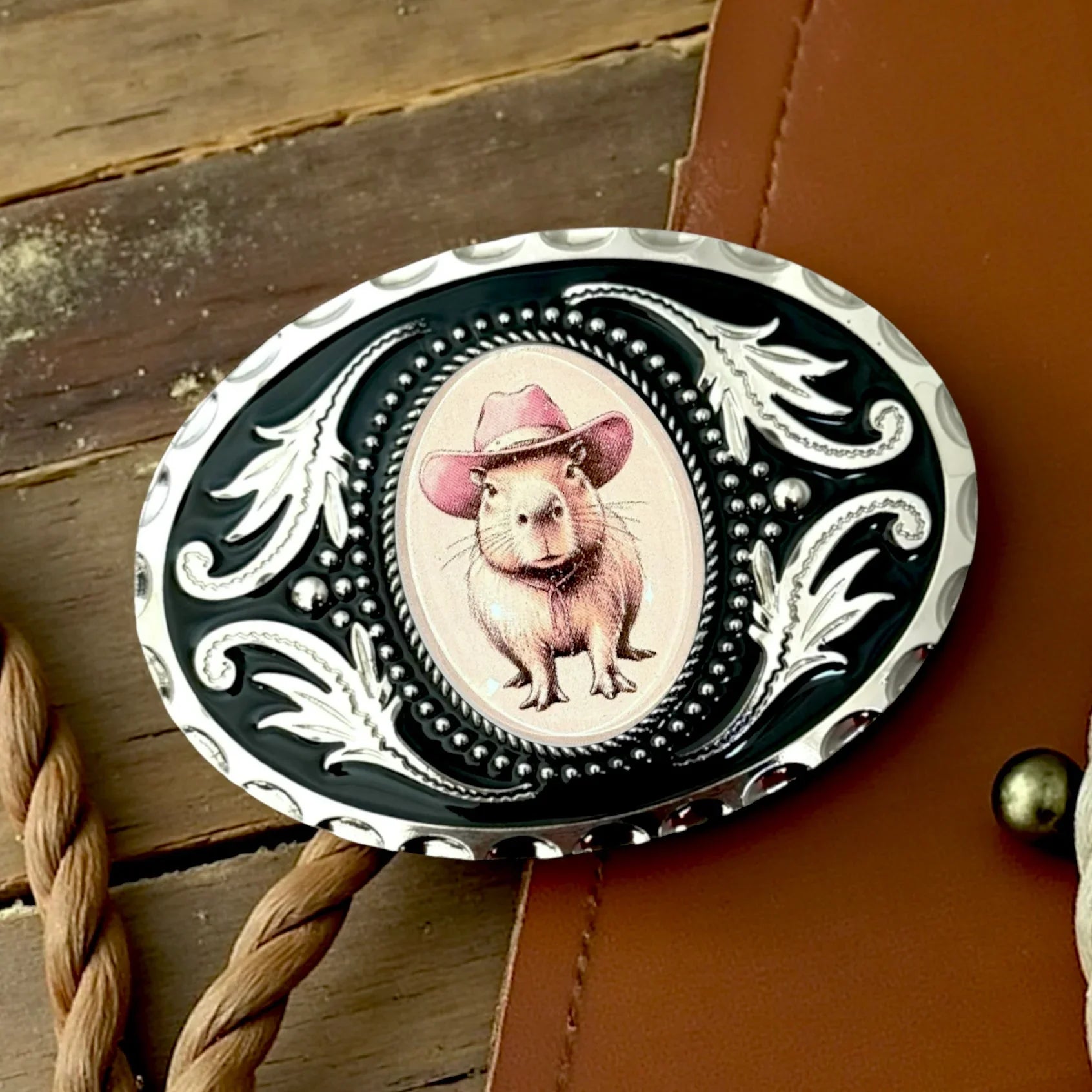 Capybara belt buckle in silver and black oval.