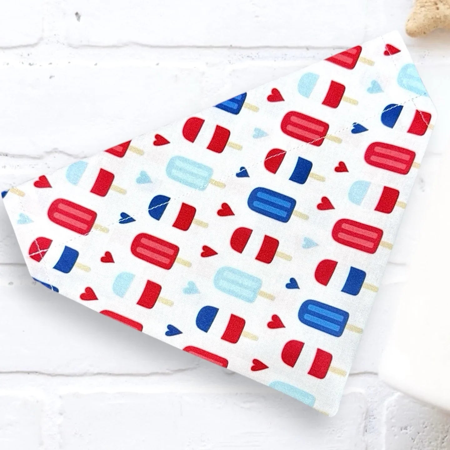 Dog bandana with red, blue, and white popsicle pattern on a white background