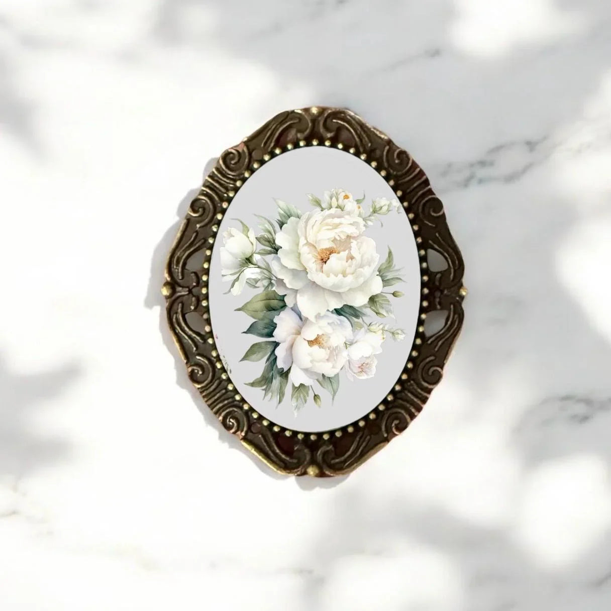 Decorative brooch with floral design on a marble background