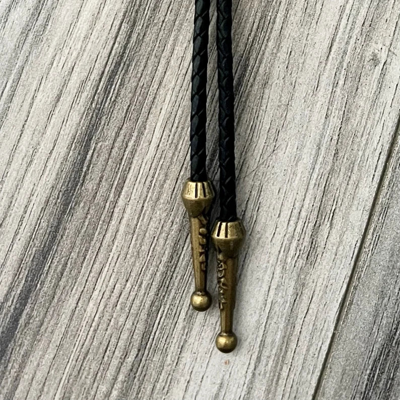 Bronze tassels of bolo tie on black leather cord