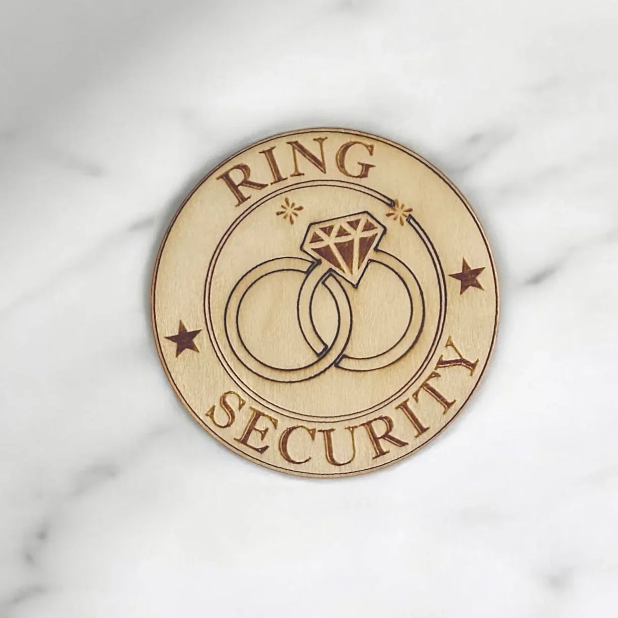 Ring bearer badge, circular made from wood in the USA and says "ring security."