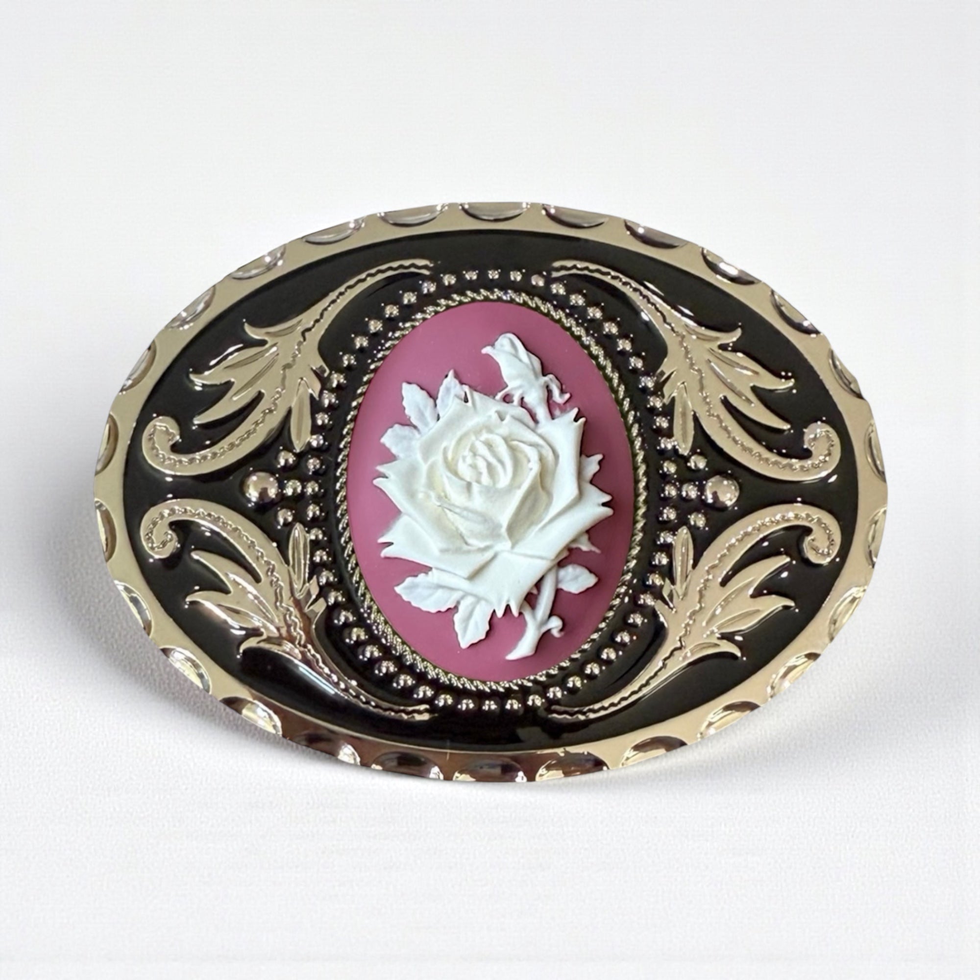 Decorative belt buckle with rose design on a white background