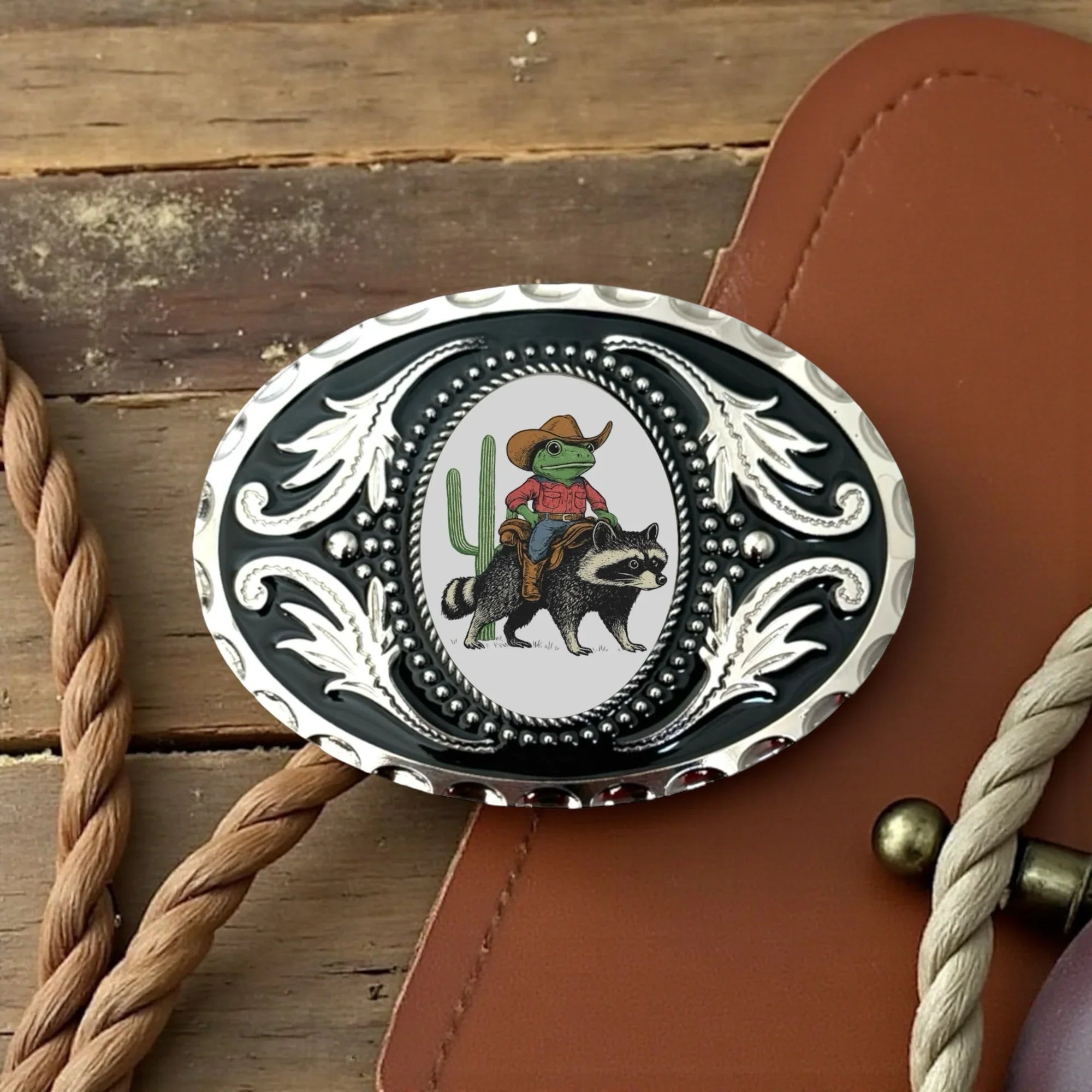 Funny belt buckle with raccoon and frog.