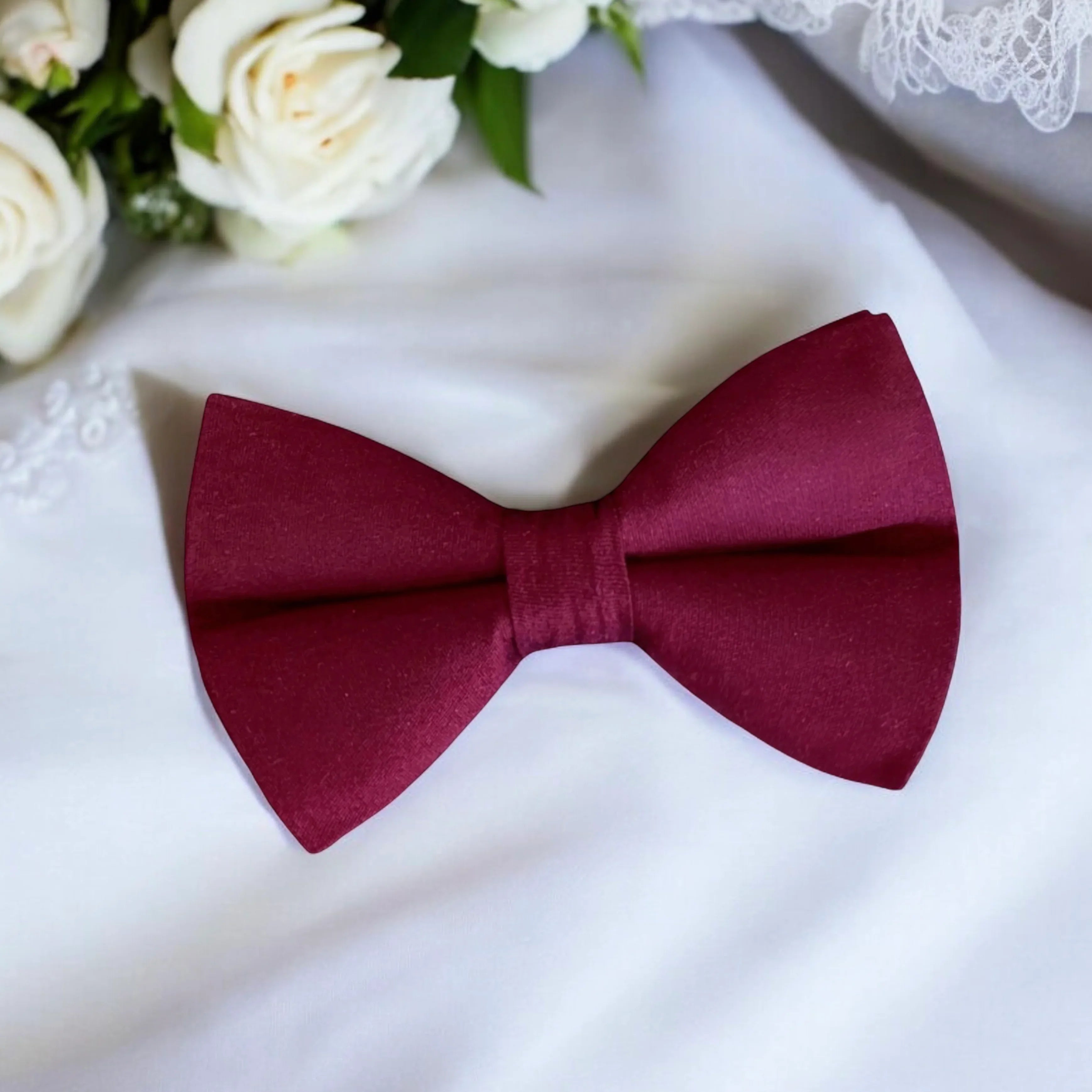 Size chart for pre-tied bow ties from The Bold Bow Tie detailing measurements across three sizes. Small is 3.5 inches wide and recommended for ages 6 months to 5 years. Medium is 4 inches wide and recommended for ages 6 to 12 years. Large is 4.5 inches wide and recommended for ages 13 years and up. Visual icons illustrate the relative sizes with horizontal arrows showing that width is measured from wingtip to wingtip. Bottom text notes that all bow ties are pre-tied and ready to add to your outfit.