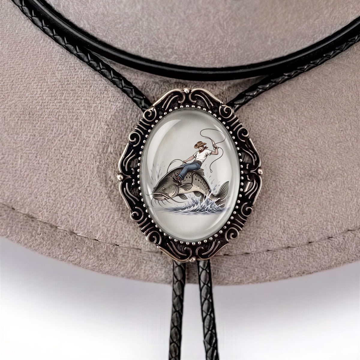 A close-up of a bolo tie with a fish design, featuring a person riding a fish.