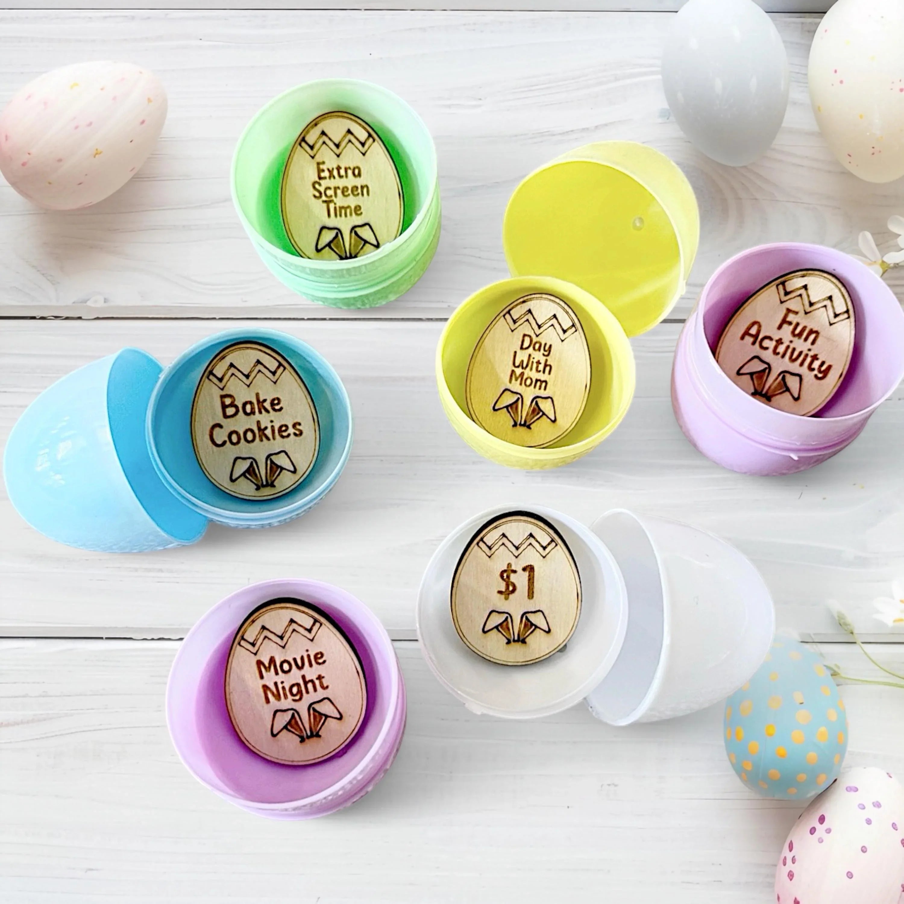 Set of wooden Easter tokens with various activity prompts inside pastel egg shaped containers