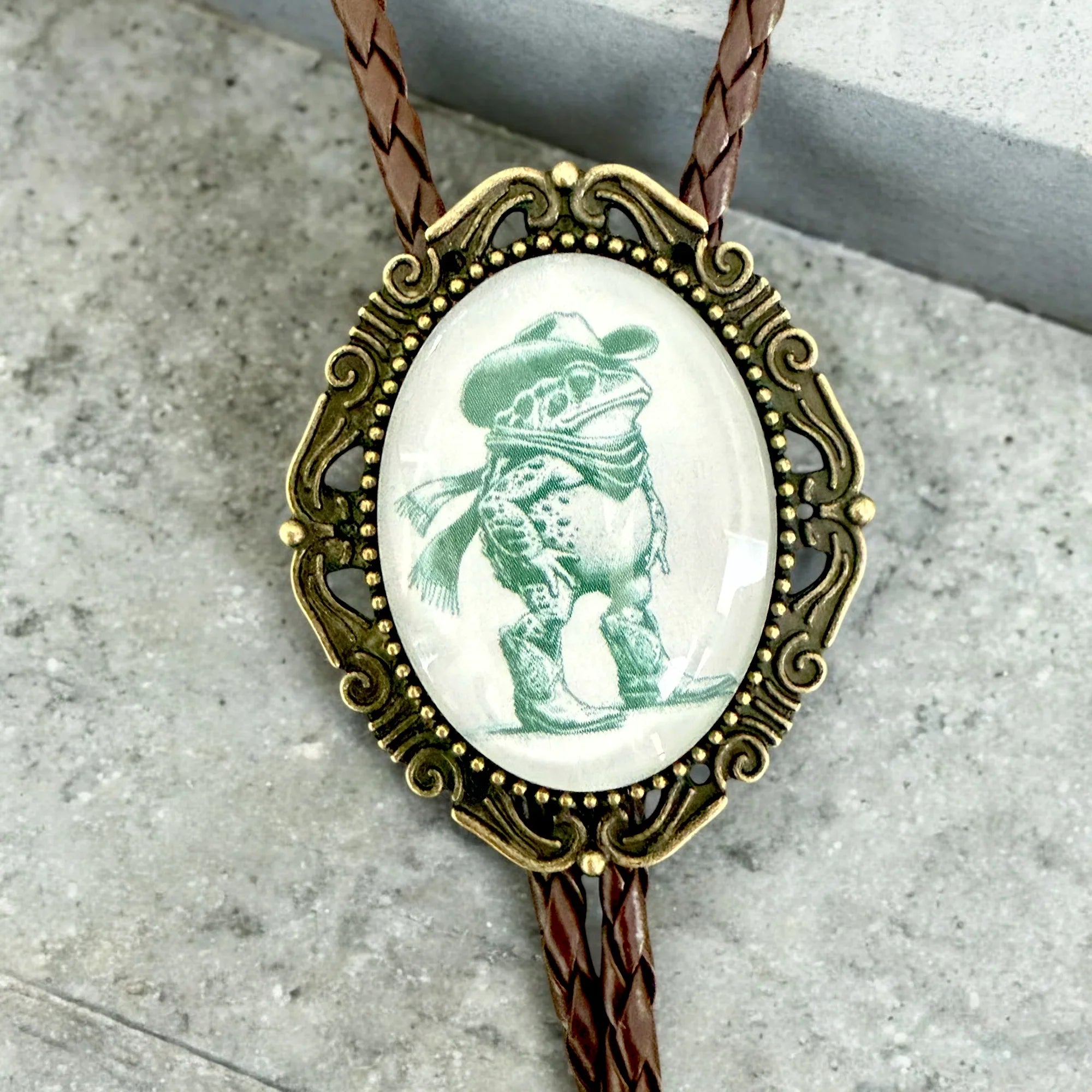 Bolo tie with green frog with bronze pendant and leather cord for men and women.