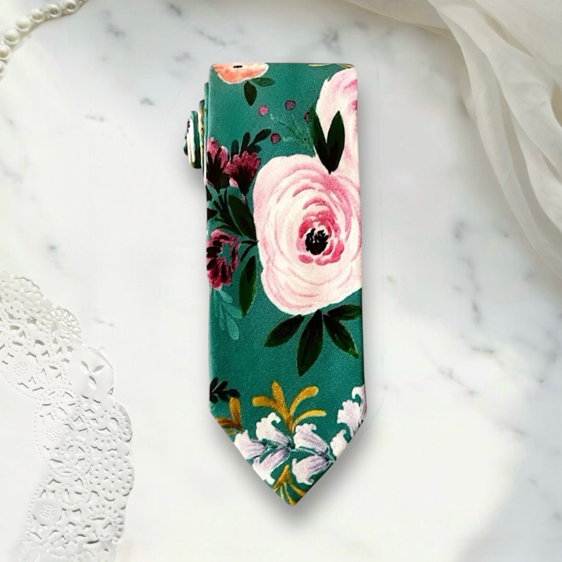 Teal floral necktie for men for wedding on a white marble counter
