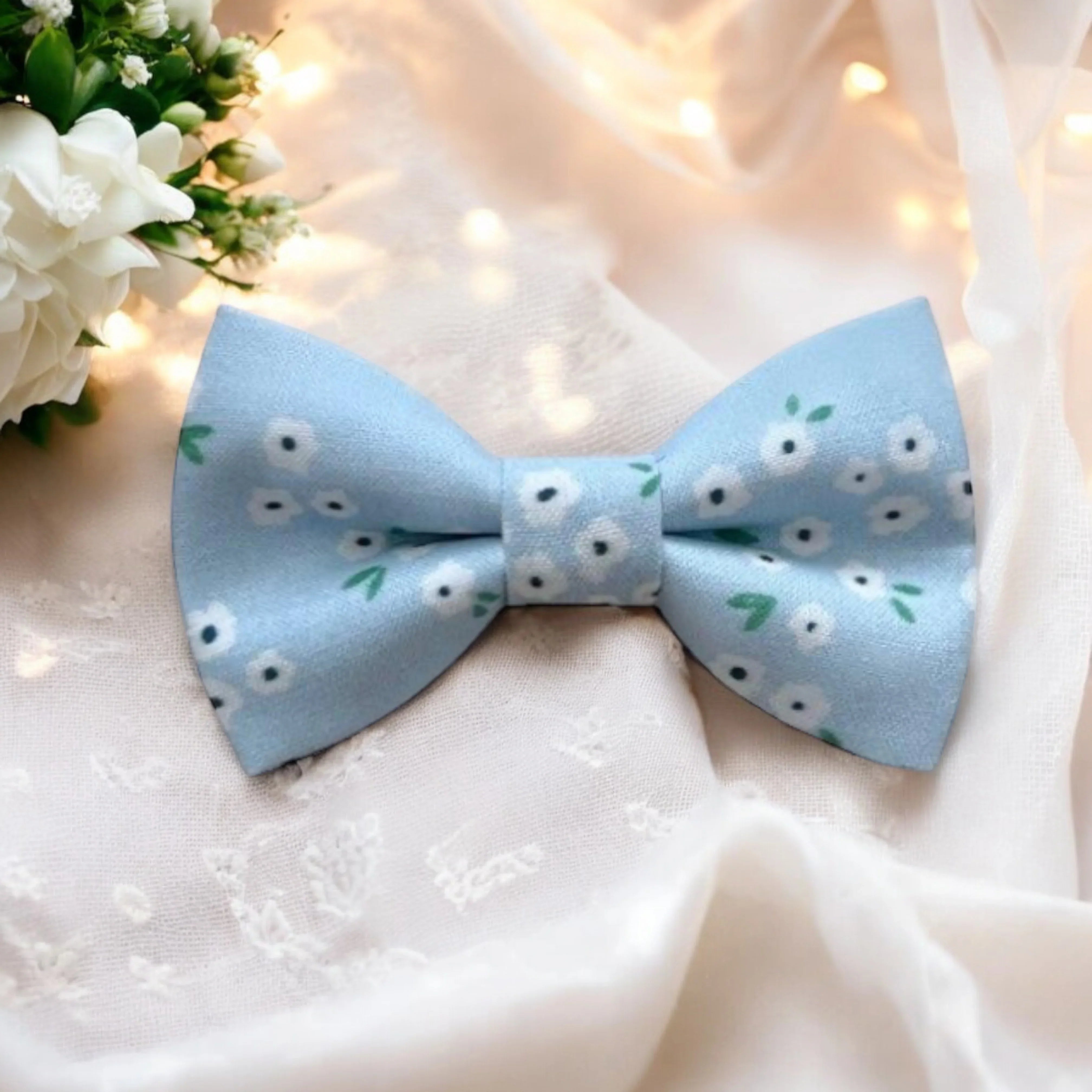 Size chart for pre-tied bow ties from The Bold Bow Tie detailing measurements across three sizes. Small is 3.5 inches wide and recommended for ages 6 months to 5 years. Medium is 4 inches wide and recommended for ages 6 to 12 years. Large is 4.5 inches wide and recommended for ages 13 years and up. Visual icons illustrate the relative sizes with horizontal arrows showing that width is measured from wingtip to wingtip. Bottom text notes that all bow ties are pre-tied and ready to add to your outfit.