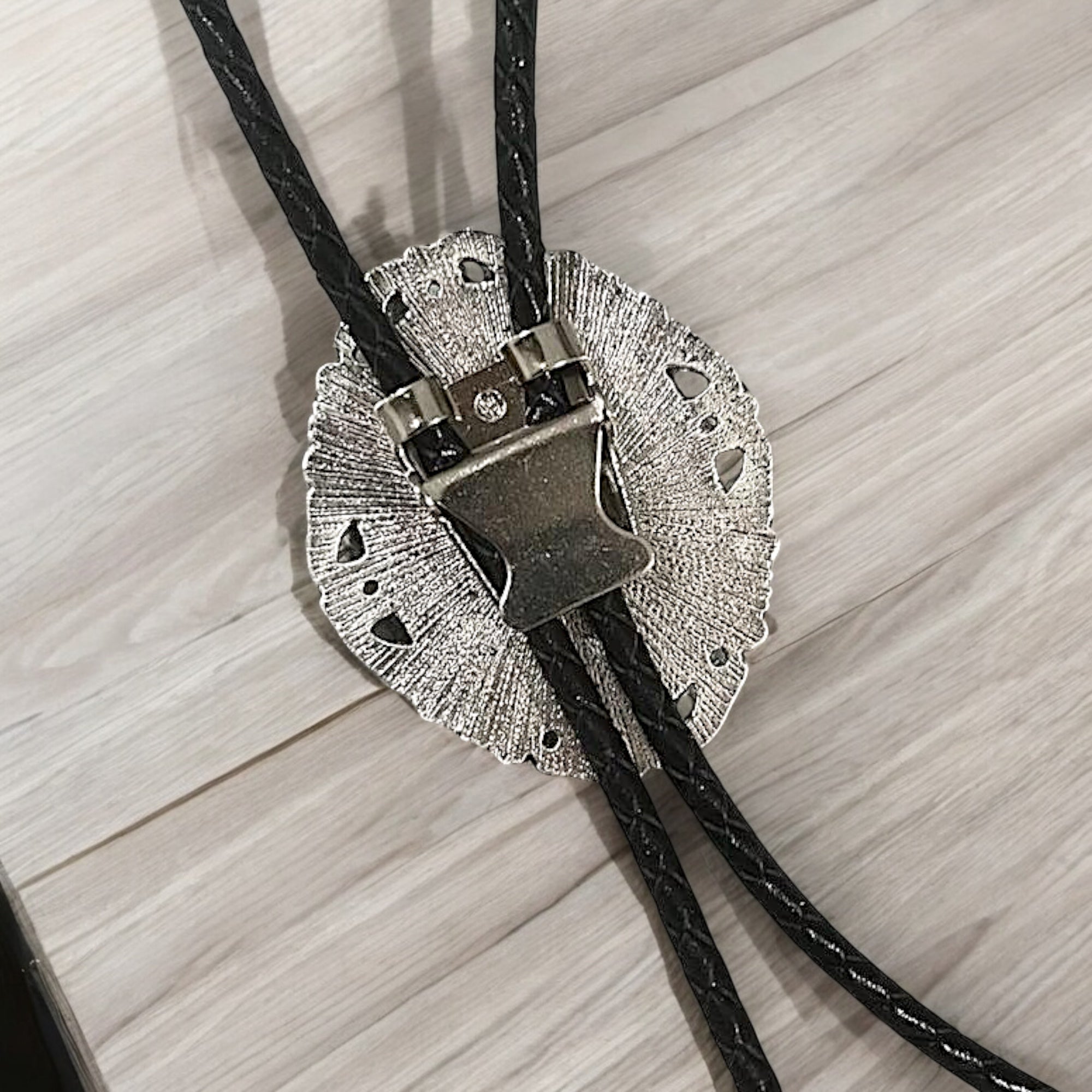 Back of silver clasp with black cord