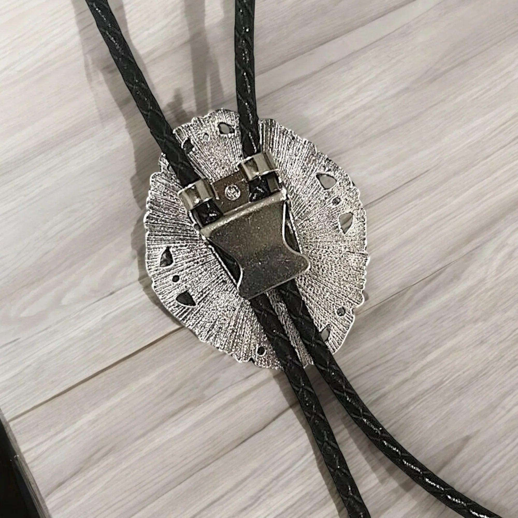 Back of silver clasp with black cord