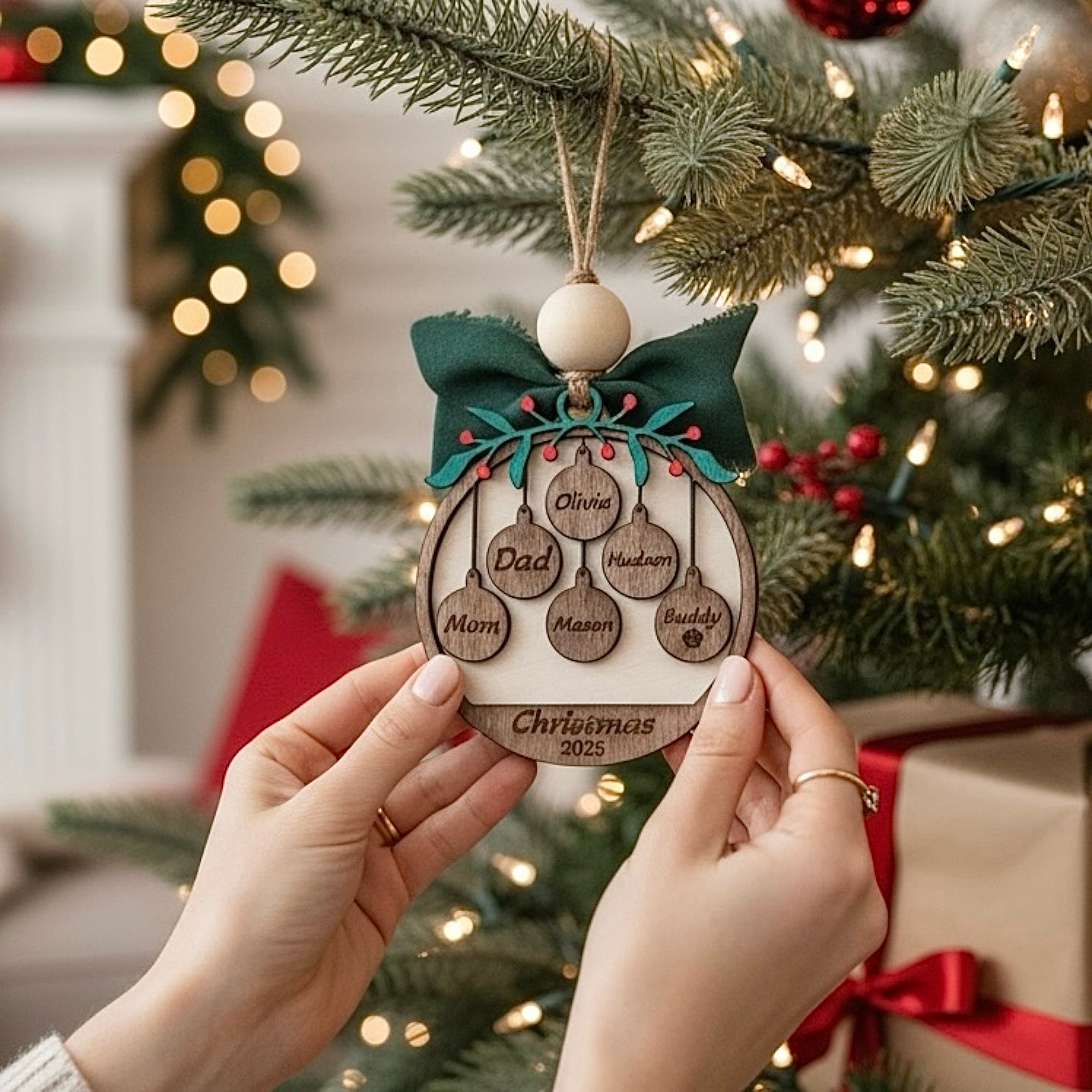 Person holding a personalized Christmas ornament with family names against a festive background.