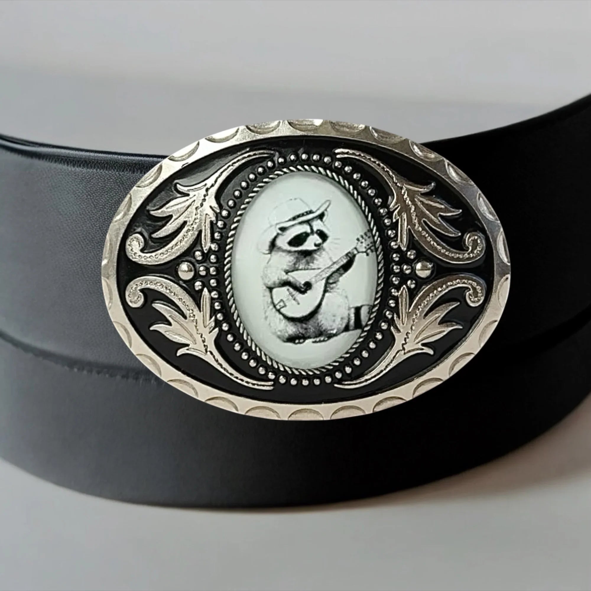 Funny belt buckle with raccoon on black leather belt.