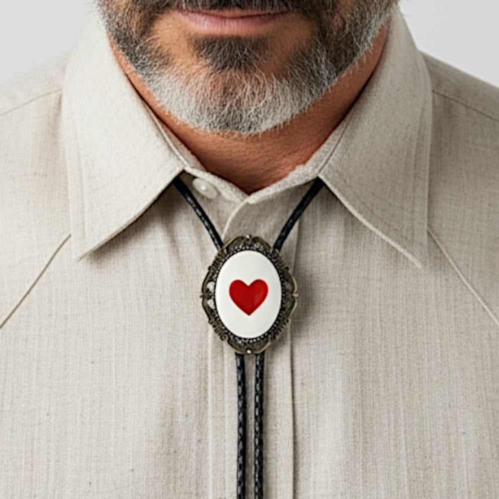 Bolo tie size chart from The Bold Bow Tie. The image displays a braided leather bolo tie with a round silver concho-style slide and silver metal tips, set against a multi-colored striped fabric background. A vertical dotted arrow on the right spans the full length of the piece, accompanied by text indicating a 39 inch cord length.
