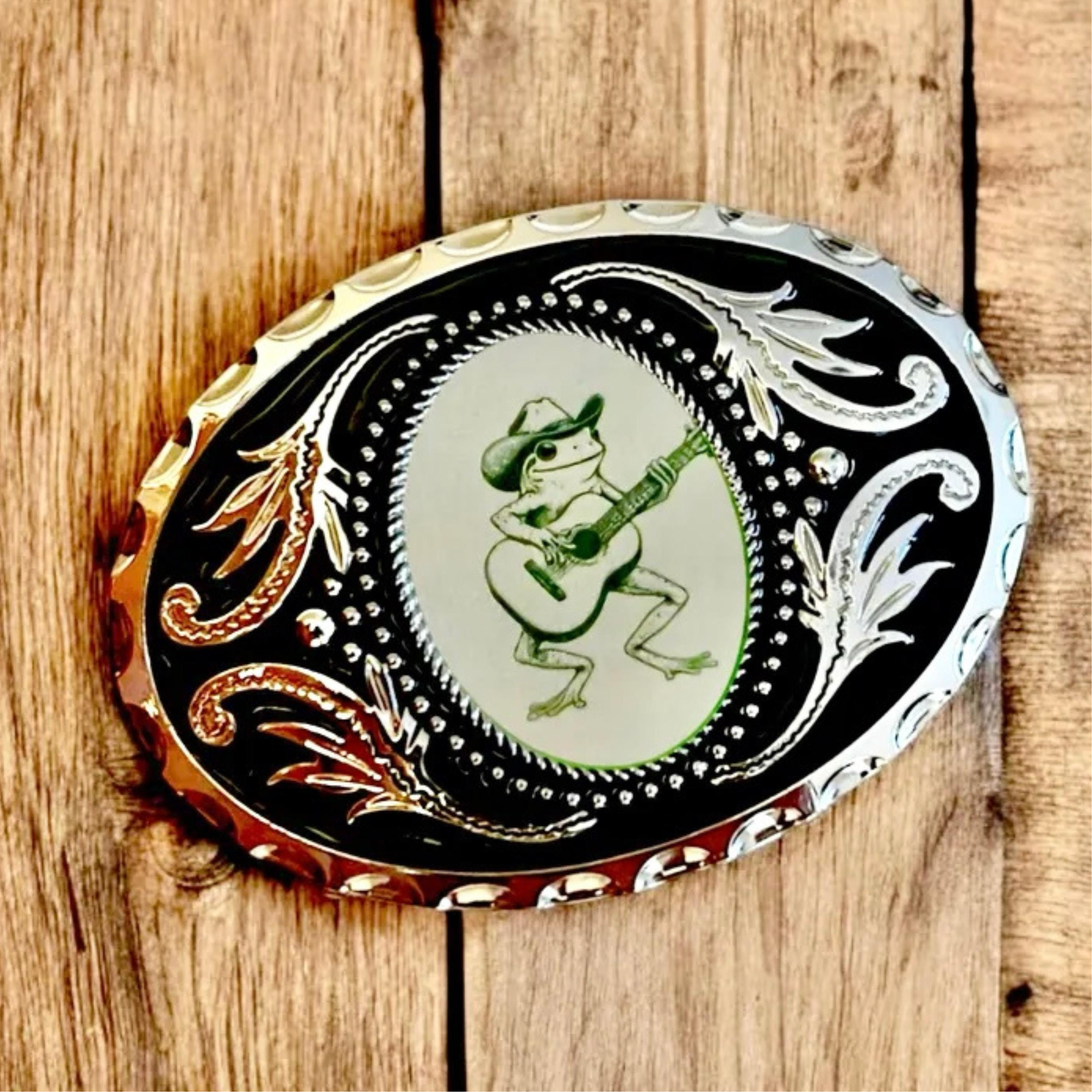 Silver Belt Buckle with green frog, Western Cowboy Accessory on wood table
