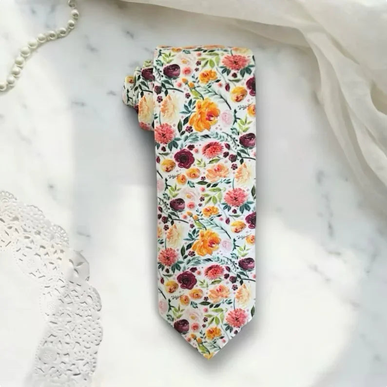 Floral patterned men’s tie for wedding and groomsmen on a marble surface