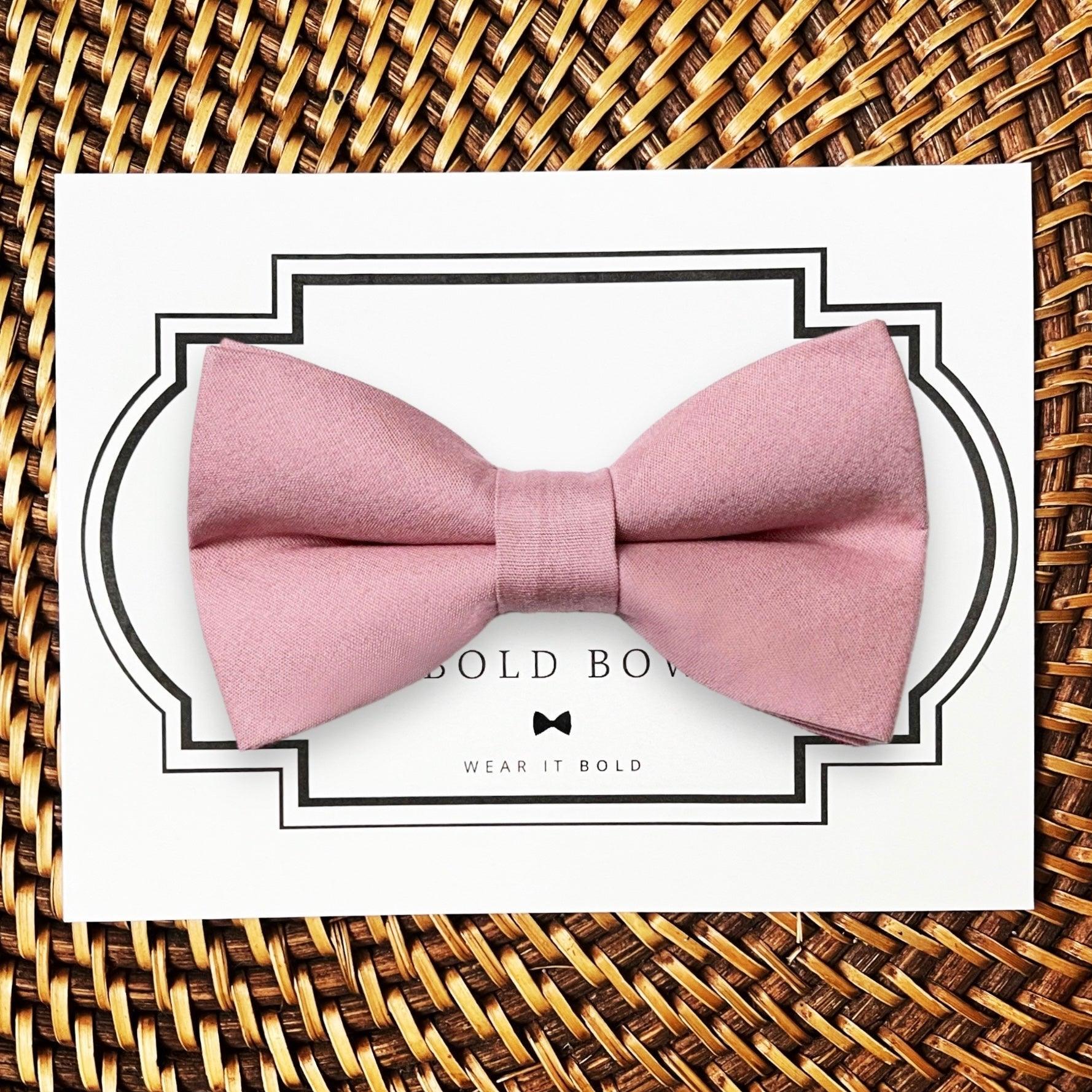 Product graphic showcasing the back of a pre-tied bow tie in a red and black buffalo plaid pattern, resting on a rustic wood surface. Two black elastic loops are attached to the center knot to slide onto a pet collar. Overlay text reads: Back of Bow Tie (may not be actual bow tie in listing).