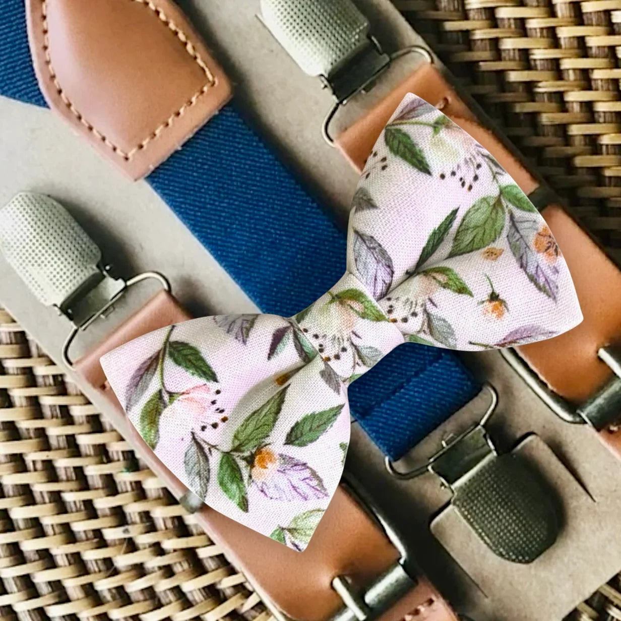 Floral pink bow tie with suspenders on a woven surface