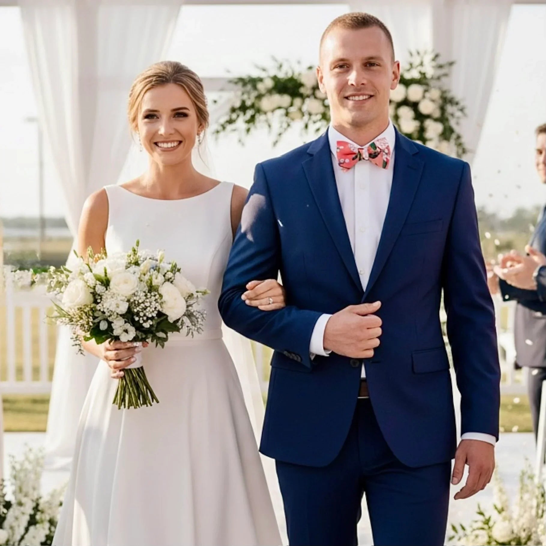 Pink floral bow tie for men worn by a groom at a wedding.