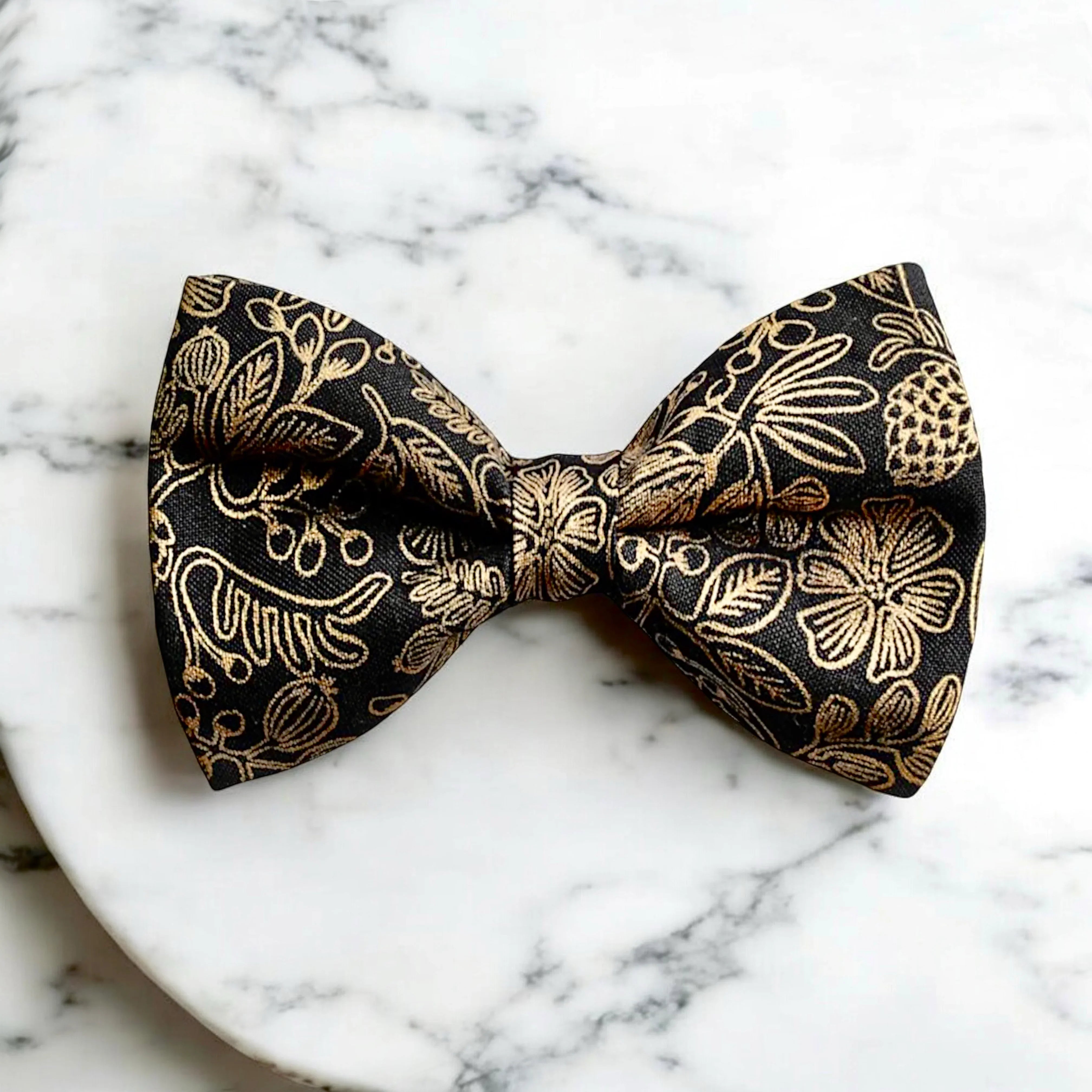 Size chart for pre-tied bow ties from The Bold Bow Tie detailing measurements across three sizes. Small is 3.5 inches wide and recommended for ages 6 months to 5 years. Medium is 4 inches wide and recommended for ages 6 to 12 years. Large is 4.5 inches wide and recommended for ages 13 years and up. Visual icons illustrate the relative sizes with horizontal arrows showing that width is measured from wingtip to wingtip. Bottom text notes that all bow ties are pre-tied and ready to add to your outfit.
