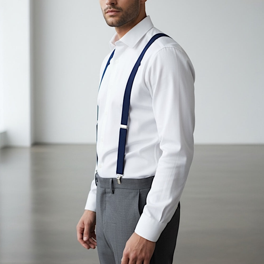 Man wearing navy suspenders for men, a white dress shirt, gray pants to be a groomsman in a wedding.