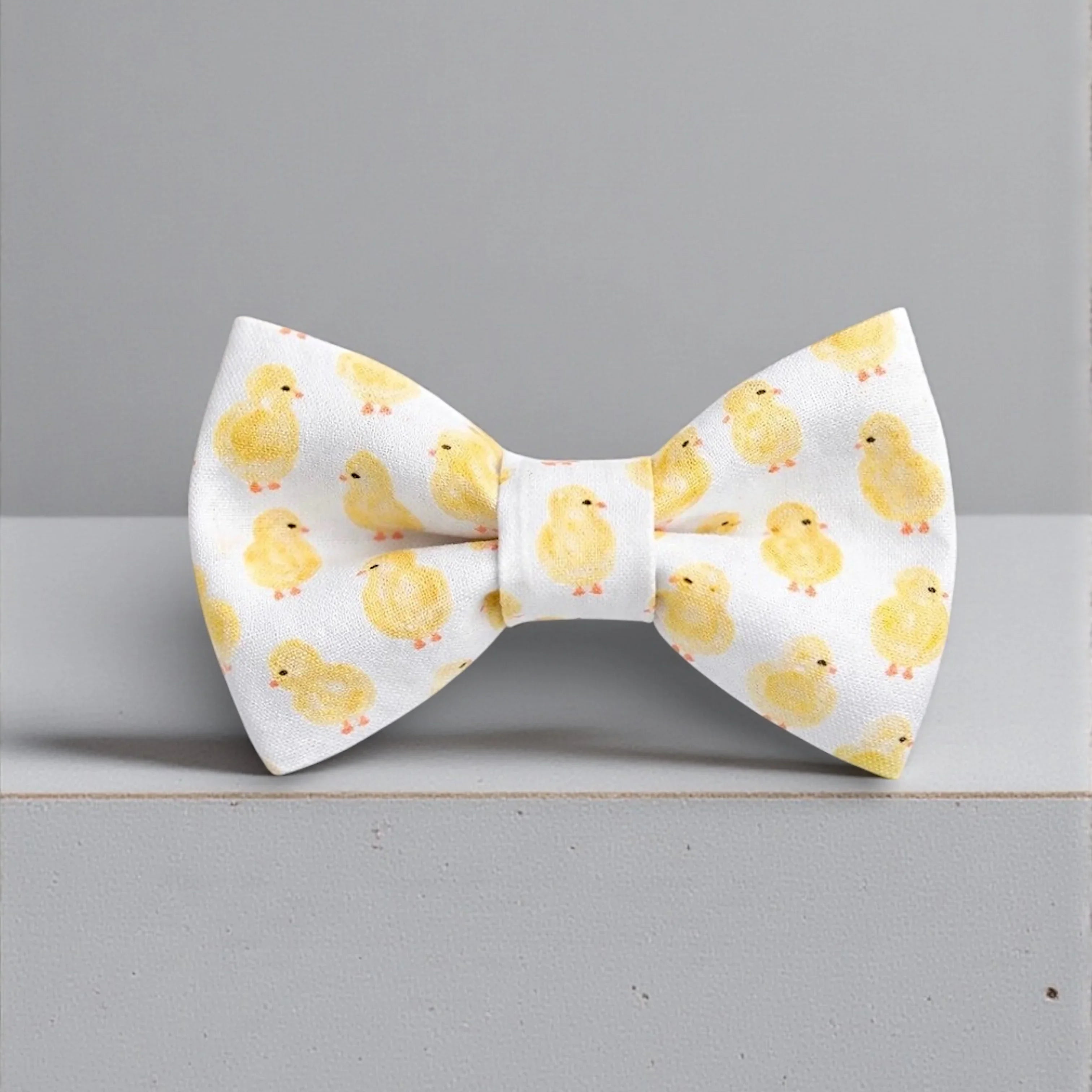 Size chart for pre-tied bow ties from The Bold Bow Tie detailing measurements across three sizes. Small is 3.5 inches wide and recommended for ages 6 months to 5 years. Medium is 4 inches wide and recommended for ages 6 to 12 years. Large is 4.5 inches wide and recommended for ages 13 years and up. Visual icons illustrate the relative sizes with horizontal arrows showing that width is measured from wingtip to wingtip. Bottom text notes that all bow ties are pre-tied and ready to add to your outfit.