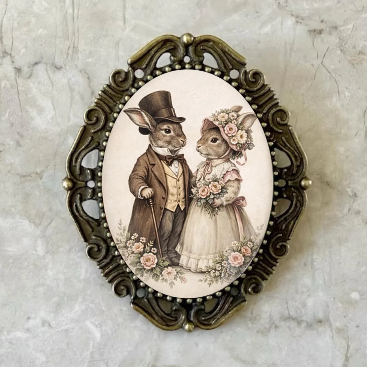 Decorative Easter bunny brooch pin with rabbits in formal attire on a marble background