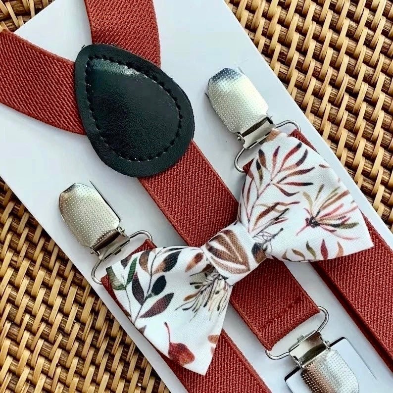 Floral bow tie and suspenders set on a woven surface