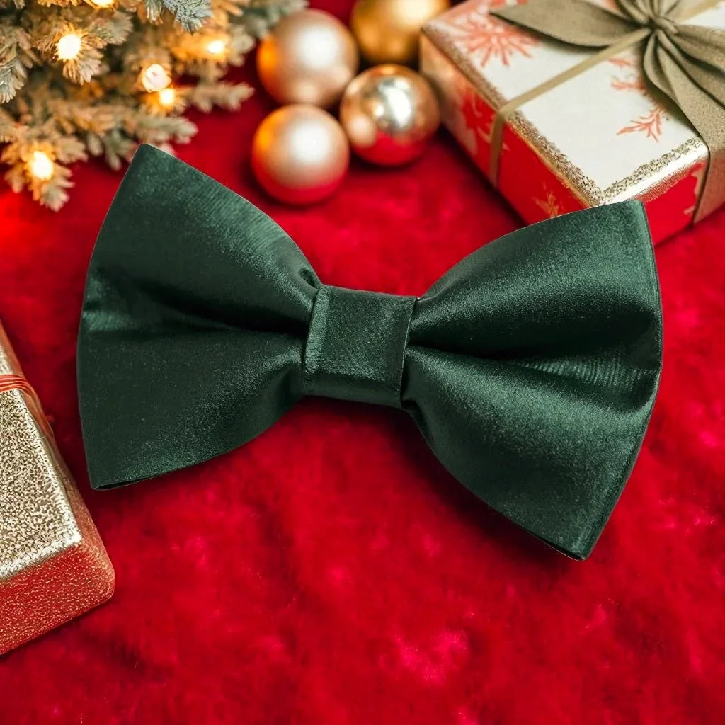 Christmas green bow tie on a red surface with Christmas decorations in the background