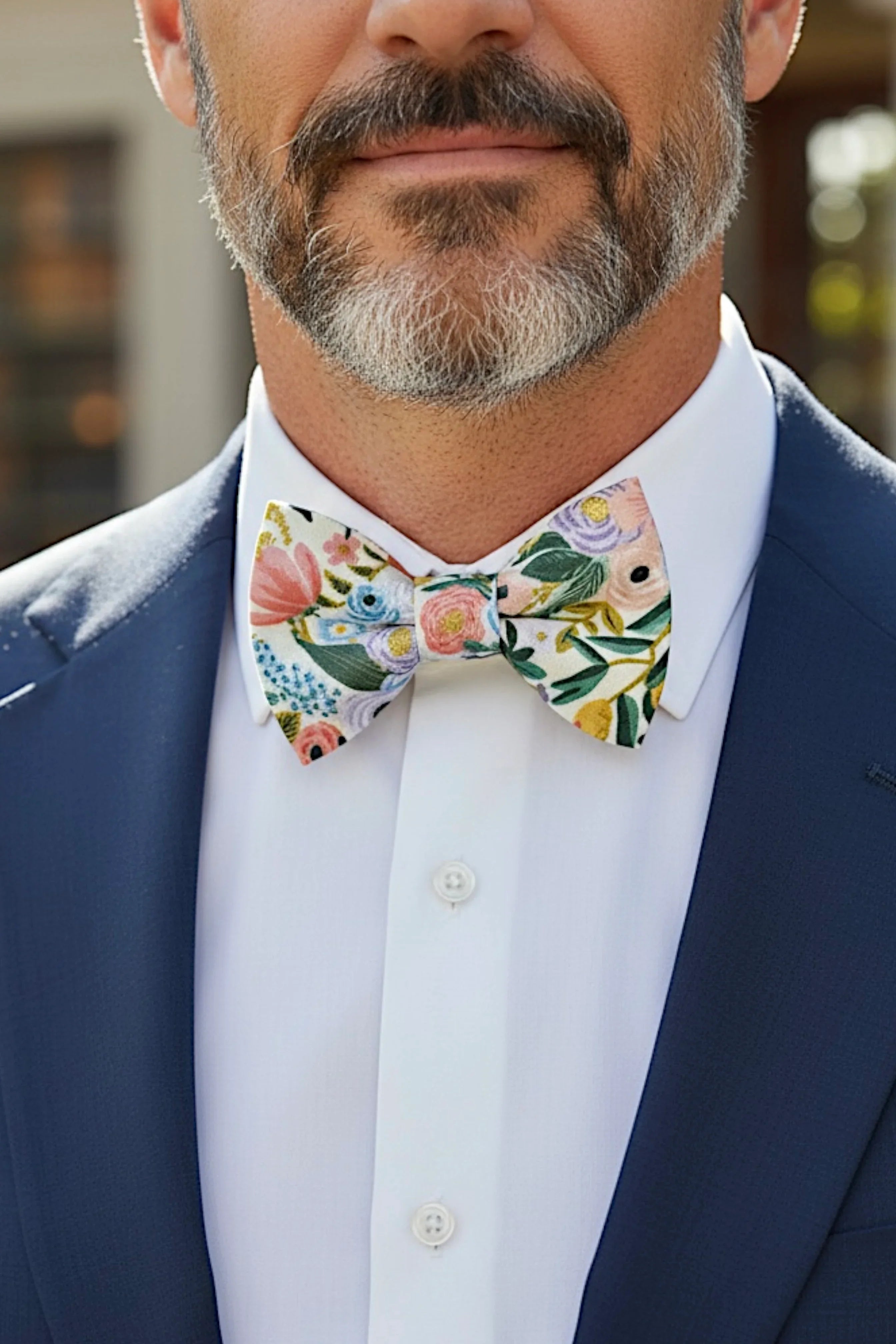 Size chart for pre-tied bow ties from The Bold Bow Tie detailing measurements across three sizes. Small is 3.5 inches wide and recommended for ages 6 months to 5 years. Medium is 4 inches wide and recommended for ages 6 to 12 years. Large is 4.5 inches wide and recommended for ages 13 years and up. Visual icons illustrate the relative sizes with horizontal arrows showing that width is measured from wingtip to wingtip. Bottom text notes that all bow ties are pre-tied and ready to add to your outfit.