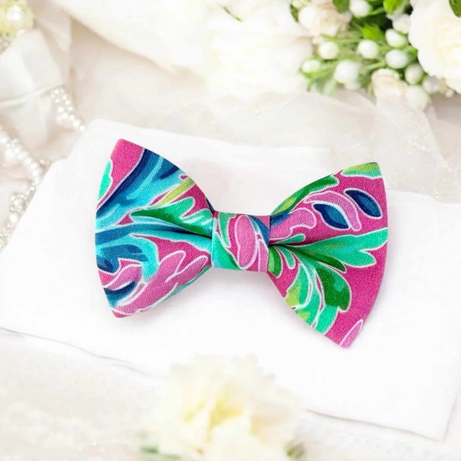Size chart for pre-tied bow ties from The Bold Bow Tie detailing measurements across three sizes. Small is 3.5 inches wide and recommended for ages 6 months to 5 years. Medium is 4 inches wide and recommended for ages 6 to 12 years. Large is 4.5 inches wide and recommended for ages 13 years and up. Visual icons illustrate the relative sizes with horizontal arrows showing that width is measured from wingtip to wingtip. Bottom text notes that all bow ties are pre-tied and ready to add to your outfit.