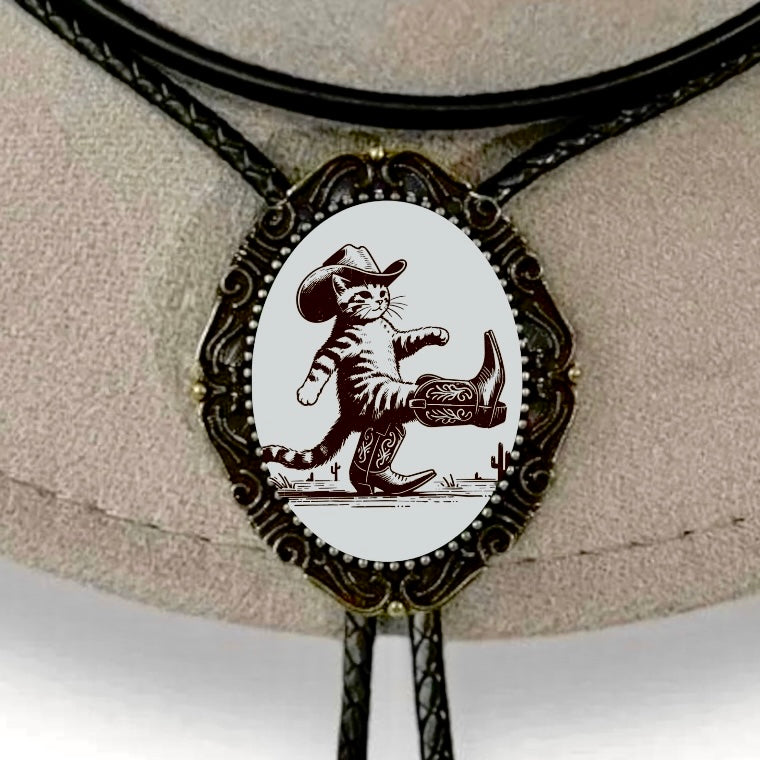 Bolo Tie with Cowboy Kitten on bronze bezel displayed on a gray cowboy hat